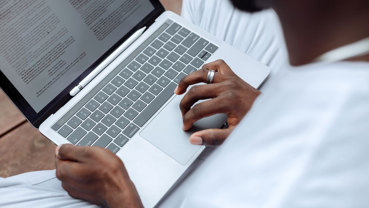 A content creator writing on a laptop